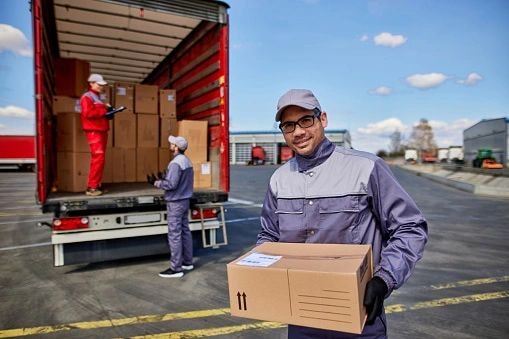Delivery worker smiling with red truck in background